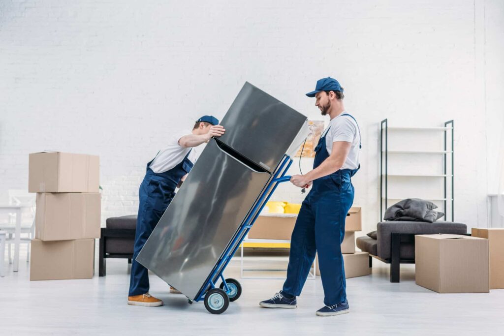 Zwei Männer transportieren Kühlschrank mit Sackkarre